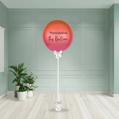 a large pink and orange balloon in a room with plants