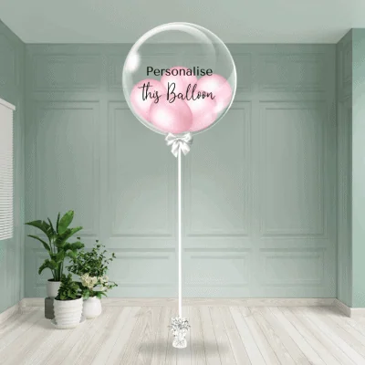 A delicate baby pink bubble balloon awaits personalisation, adding a sweet touch to the setting.