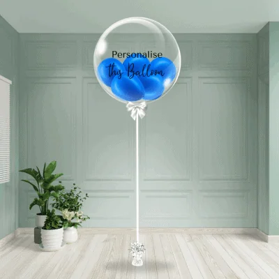 A deep blue bubble balloon on a stand invites custom messages, set in a tranquil room environment.