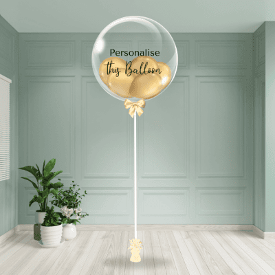 Gold chrome personalised bubble balloon tied with a golden ribbon in an elegant interior.