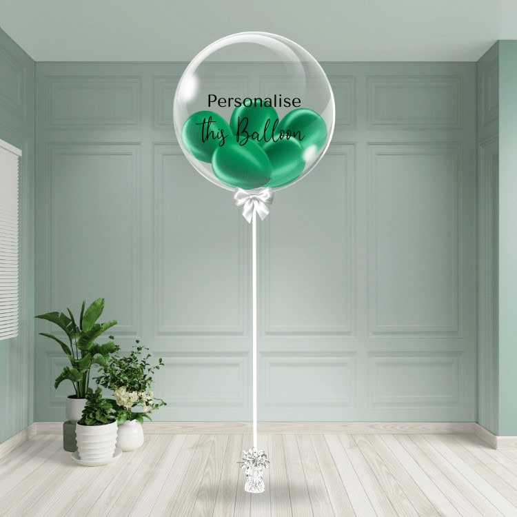 A lush green bubble balloon stands with an option for personalisation, set in a calm and elegant room.