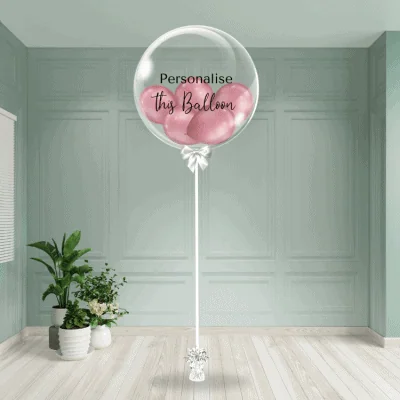 A refined mauve chrome balloon nestled inside a see-through bubble, tied with a ribbon, ready to bear your tailored message for that distinct touch.