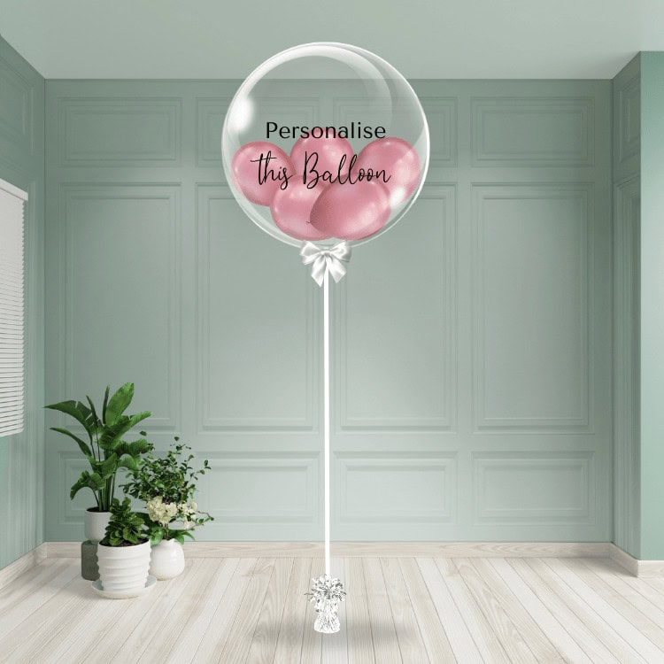 A refined mauve chrome balloon nestled inside a see-through bubble, tied with a ribbon, ready to bear your tailored message for that distinct touch.