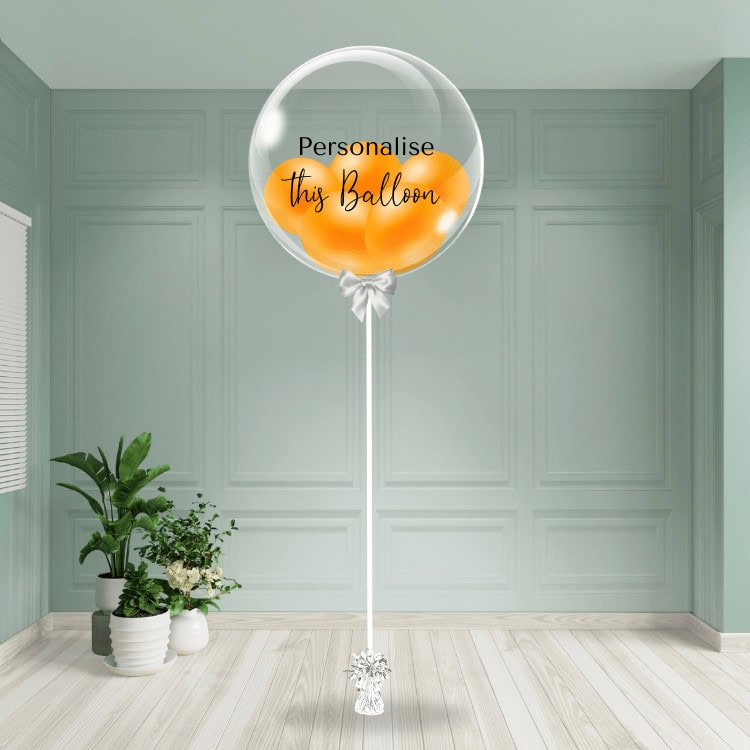 An orange bubble balloon stands ready to be customised, bringing a burst of warmth to the decor.