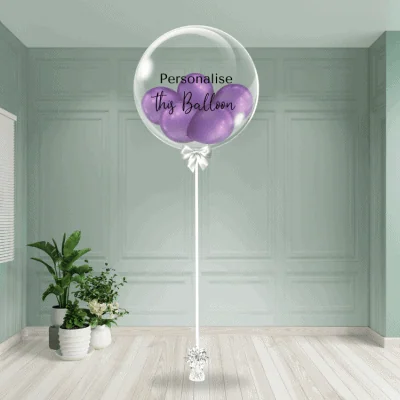Elegant purple chrome balloons nestled inside a clear bubble balloon with customisable text, presented on a stylish stand, perfect for upscale events and brand celebrations.