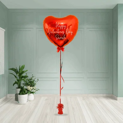 Heart-shaped red foil heart balloon with 'Happy Valentine's Day Sarah' personalised message, from Balloonista in London